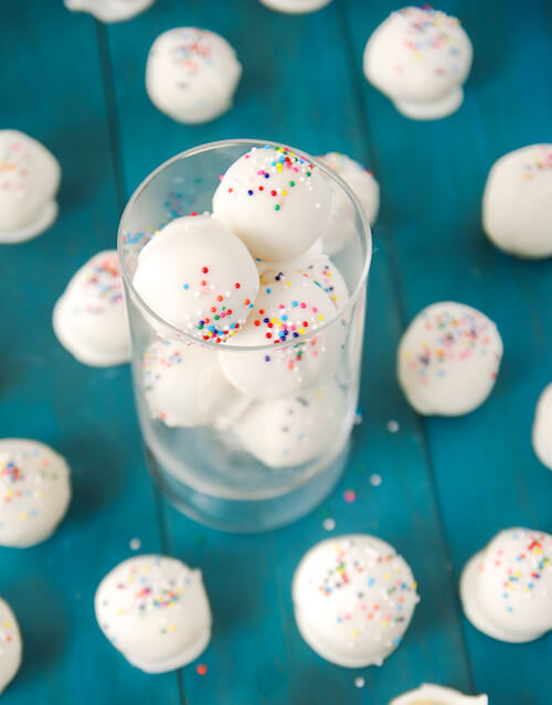 Cake batter truffles with rainbow sprinkles in a cup.