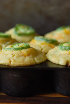 Jalapeno Sweet Corn Muffins - each topped with a slice of jalapenos in a muffin tin