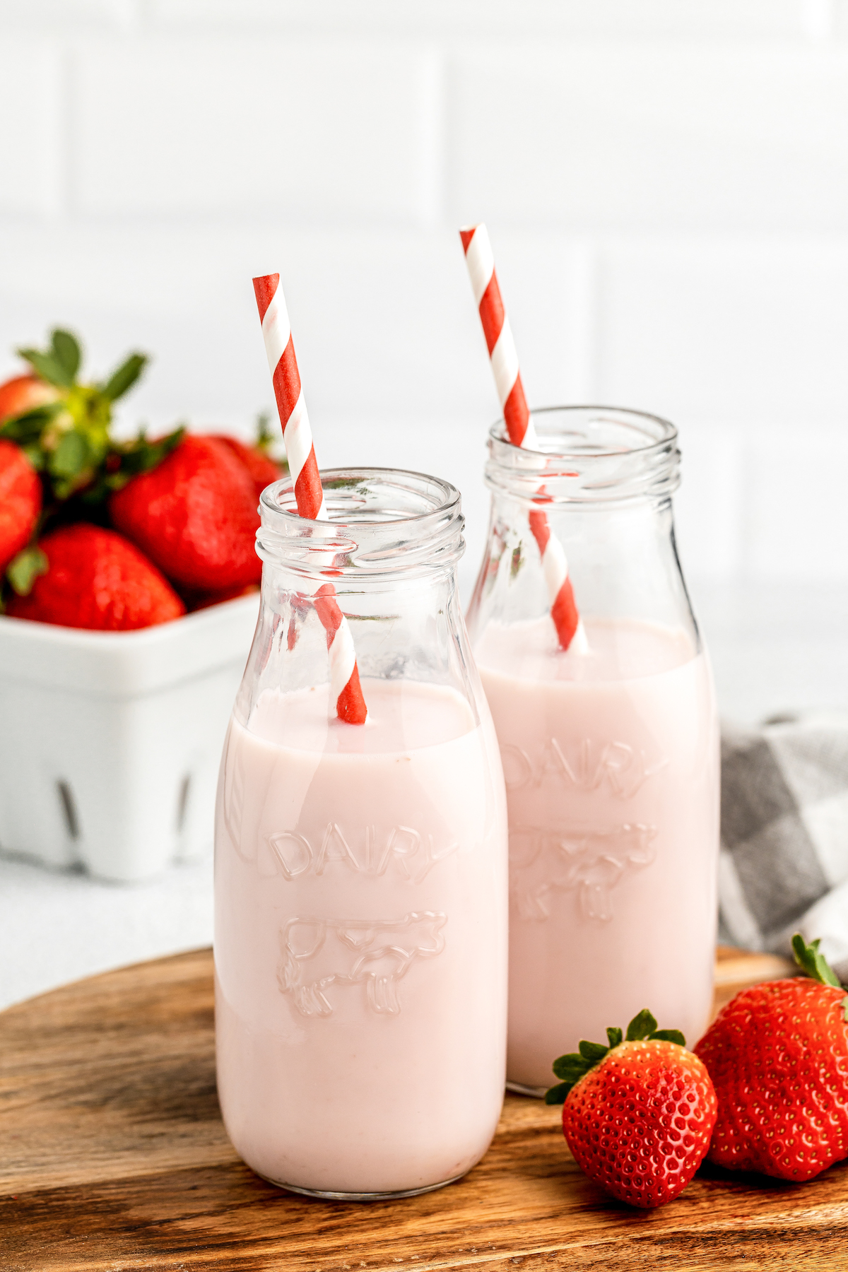 Pale pink milk in glass milk jars.