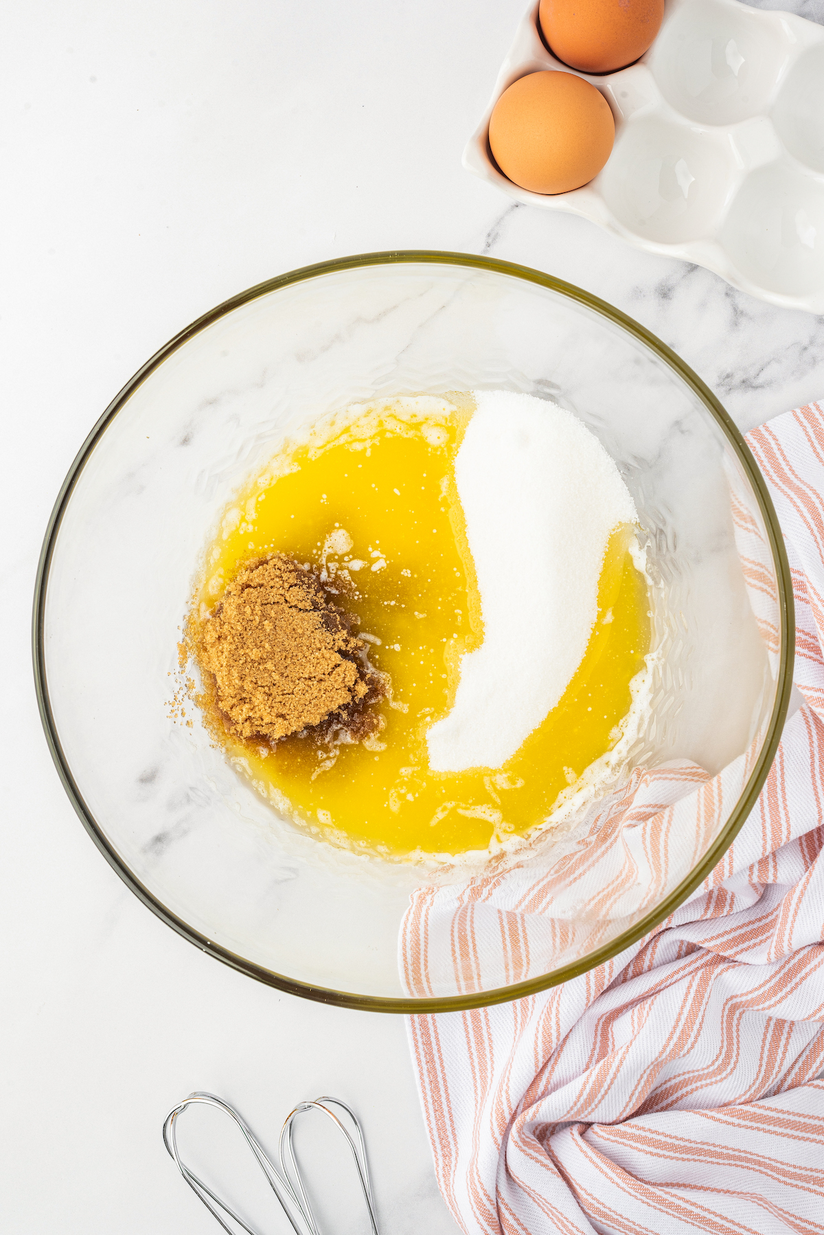 Melted butter, granulated sugar, and brown sugar in a mixing bowl.