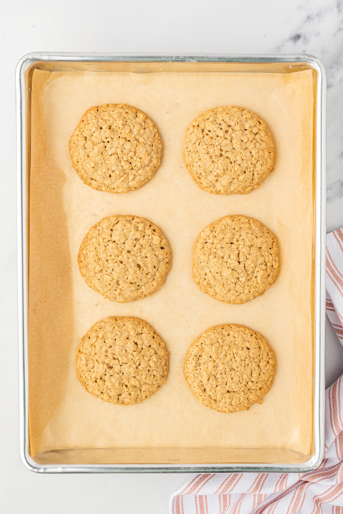 Baked old fashioned oatmeal cookies on a baking sheet.