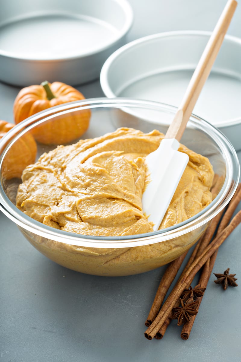 Pumpkin cake batter in a bowl with a spatula. 