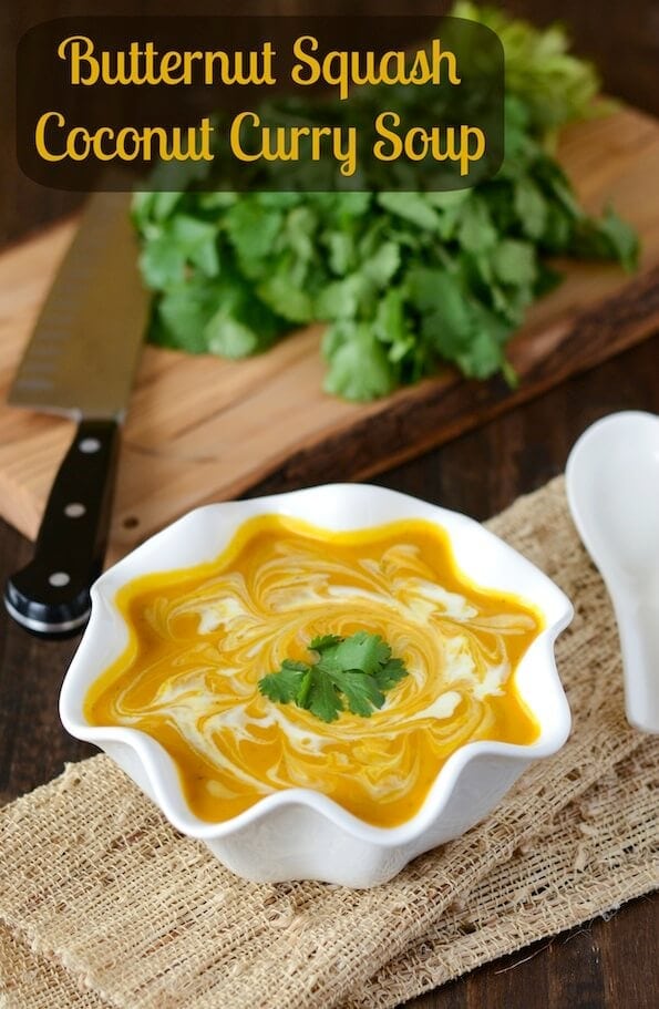 Butternut Squash Coconut Curry Soup in a white bowl topped with coconut cream