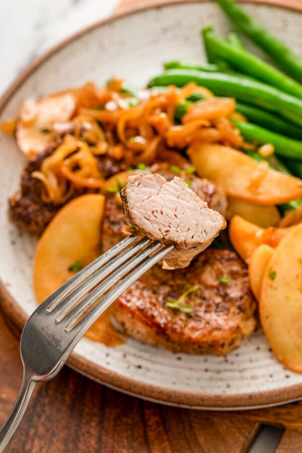 Grabbing a piece of juicy pork tenderloin with a fork.