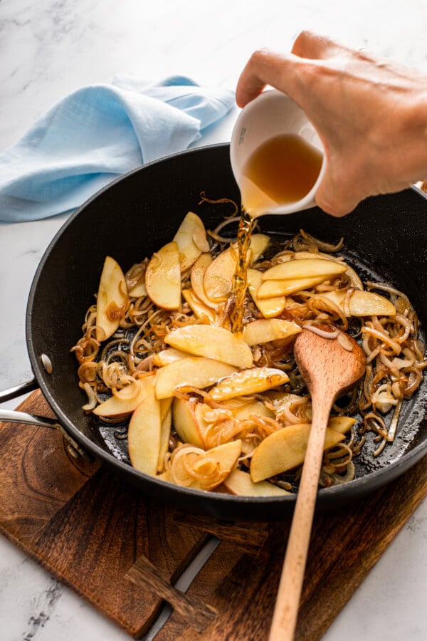 Apple cider is being poured into the pan. 