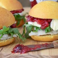Close up of Turkey Sliders loaded with brie, arugula and a savory homemade cranberry chutney