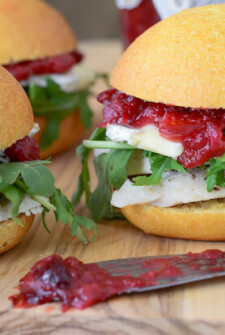 Close up of Turkey Sliders loaded with brie, arugula and a savory homemade cranberry chutney
