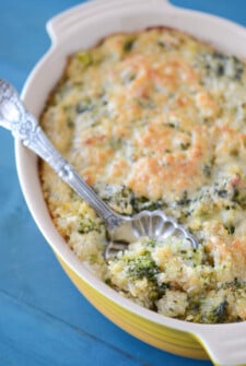 Cheesy Broccoli Quinoa Casserole in a yellow casserole dish with a silver serving spoon