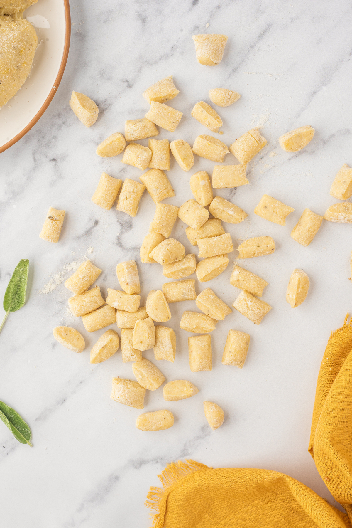 Small, bite-sized chunks of dough scattered across a marble work surface.