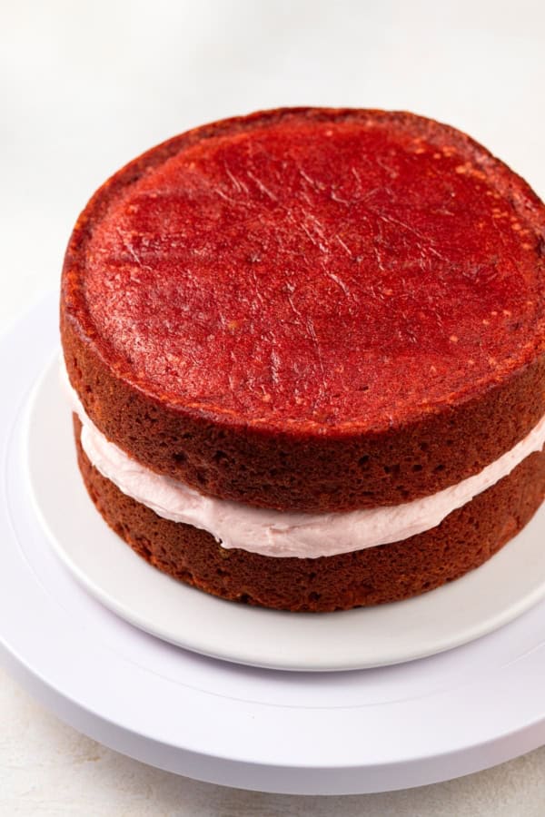 Two strawberry cake layers are sandwiched together with homemade strawberry buttercream.