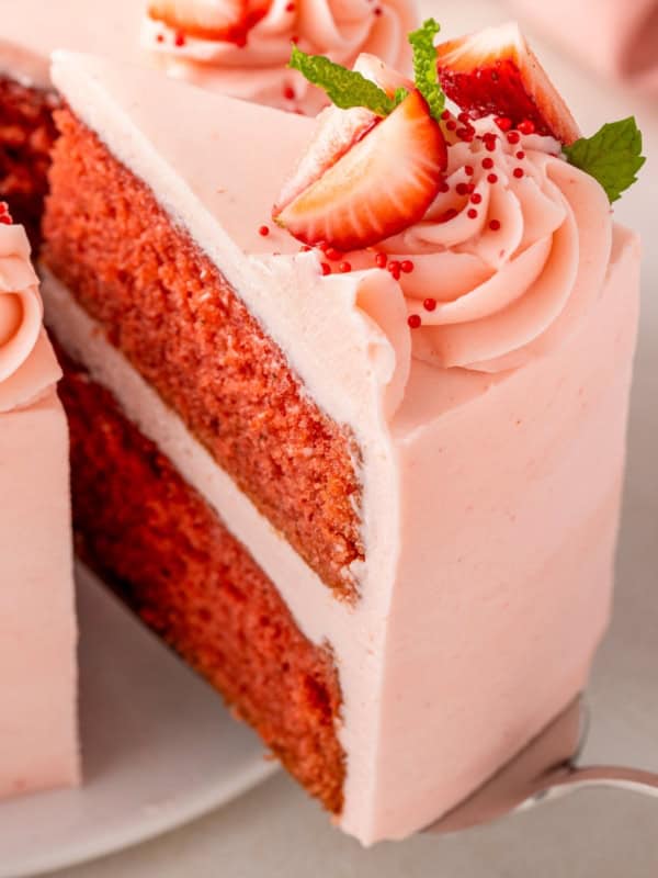 A moist homemade cake is flavored with fresh strawberry puree and topped with pink frosting.