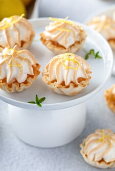 Bite-sized lemon meringue pie servings on a cake plate.