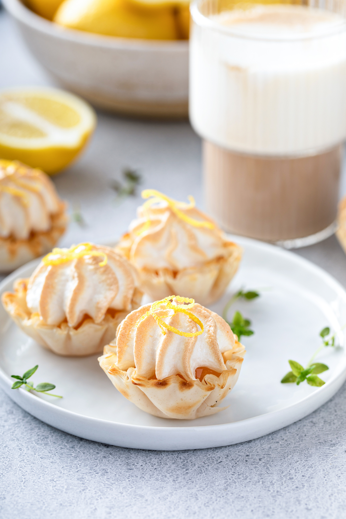Bite-sized lemon meringue pies on a small plate.