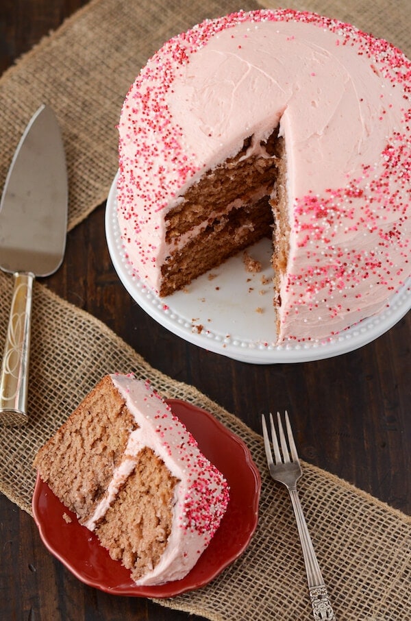 Slice of strawberry frosted cake on a red plate