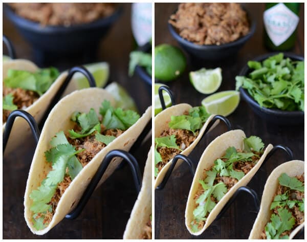 Pork Carnitas in a black taco holder with ingredients behind them