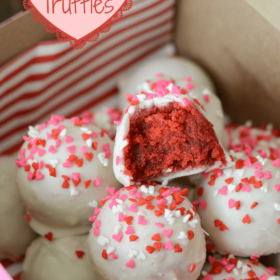 Valentine's Day Red Velvet Truffles topped with red, white, and pink heart sprinkles in a pink box
