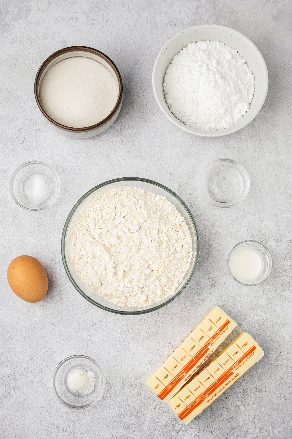 From top: Granulated sugar, powdered sugar, salt, flour, almond extract, egg, milk, baking powder, butter.