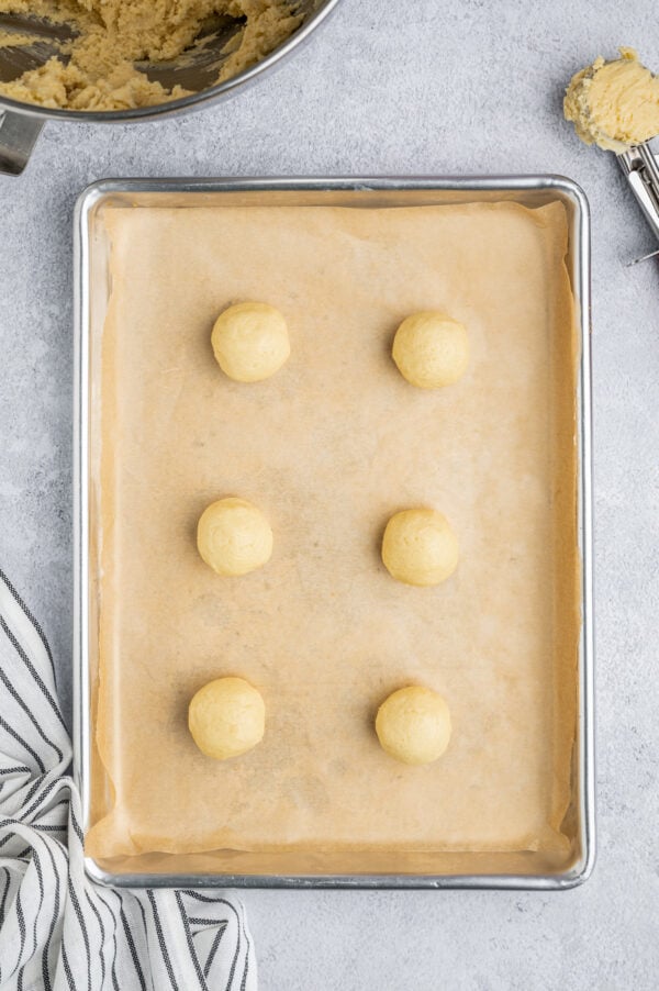 Balls of cookie dough on a baking sheet.