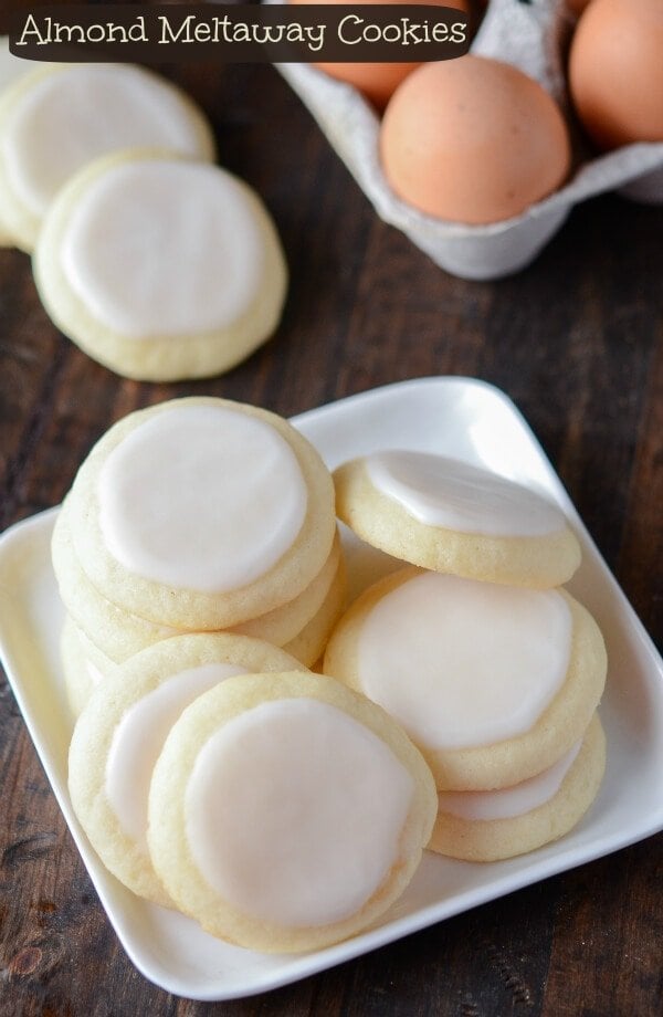 Nine Almond Meltaway Cookies on a White Plate Beside a Carton of Eggs