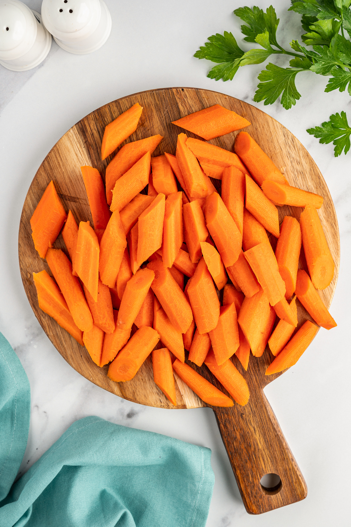 Peeled and cut carrots on a cutting board.