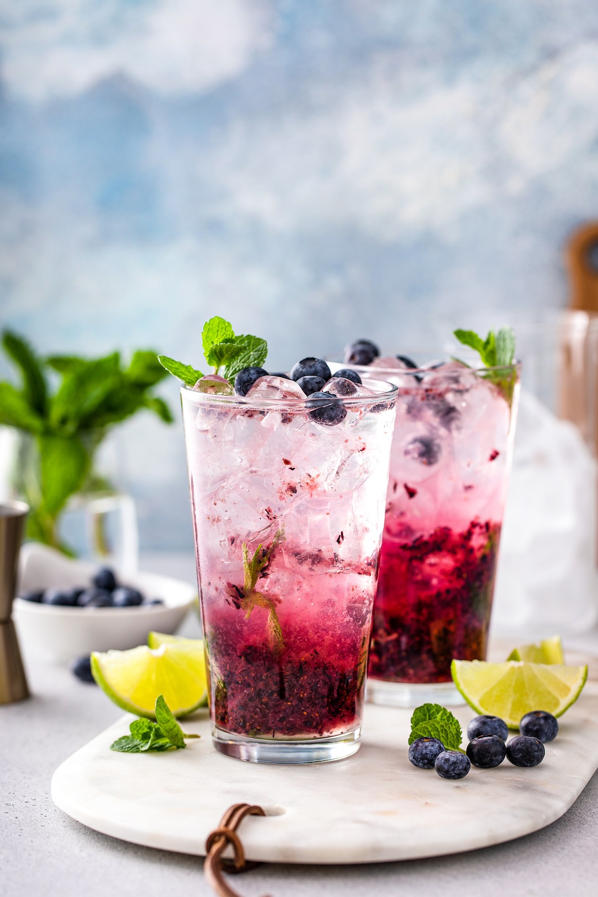 Two glasses of blueberry mojitos. 