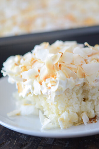 A close up shot of a big slice of Coconut Sheet Cake