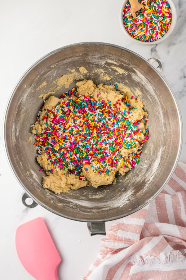 Adding sprinkles to cookie dough.