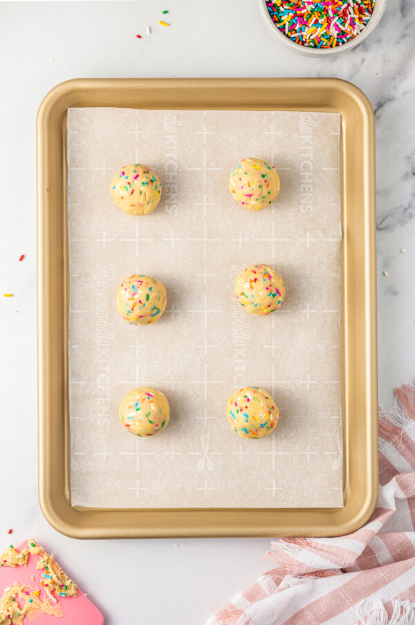 Balls of cookie dough on a baking sheet.