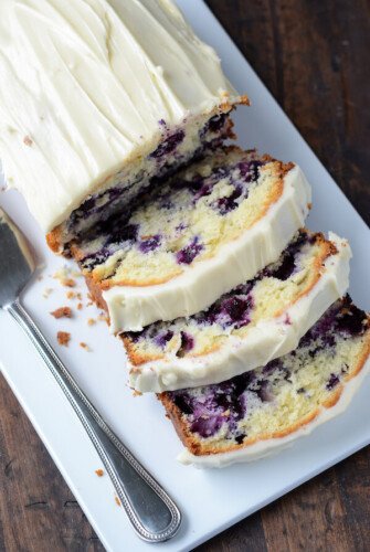 Blueberry Lime Cream Cheese Pound Cake sliced on a white platter.
