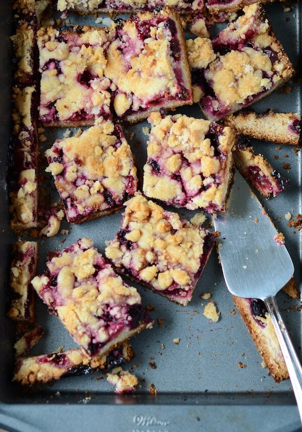 Blackberry Pie Bars topped with crumbles on a sheet pan.