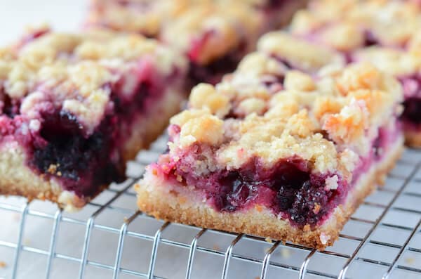 Blackberry Pie Bars topped with crumbles on a rack.