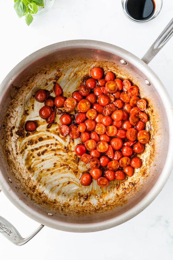 Cherry tomatoes sautéed in a pan.