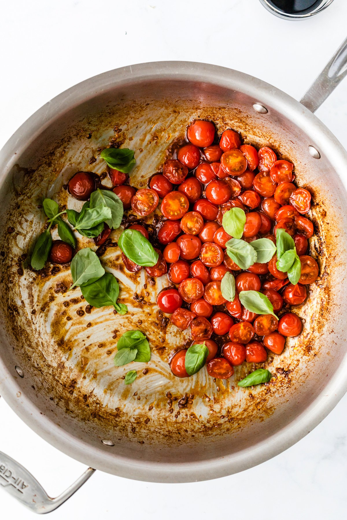 Cherry tomatoes and fresh basil in a pan.
