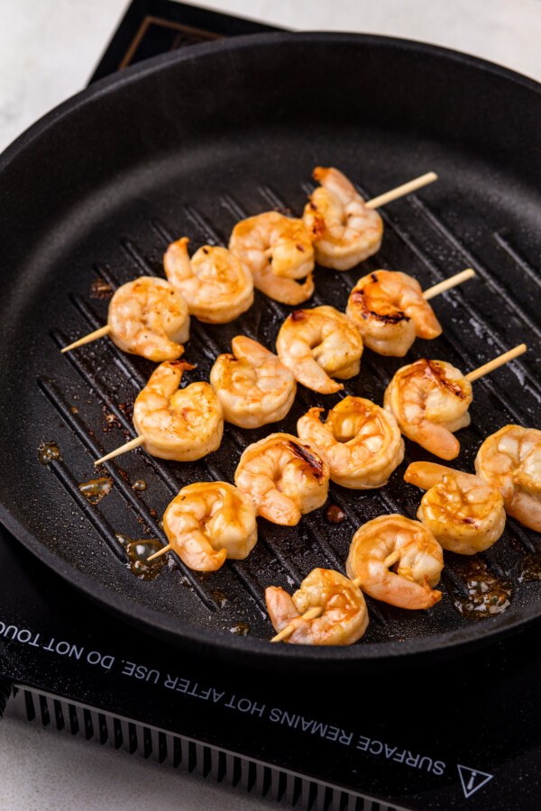 Cooking shrimp skewers on the grill pan.