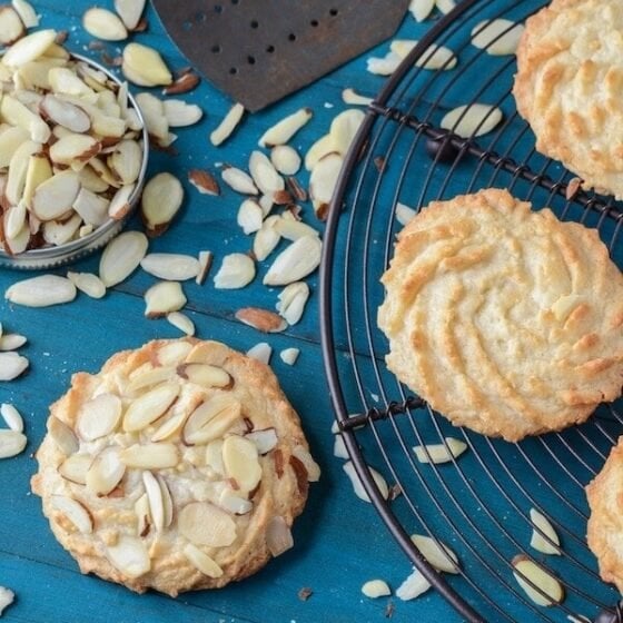 Ultimate Almond Cookies on a black rack with scattered almonds.