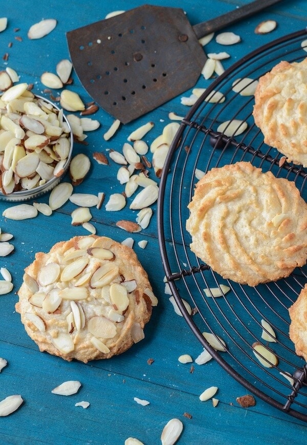 Ultimate Almond Cookies on a black rack with scattered almonds.