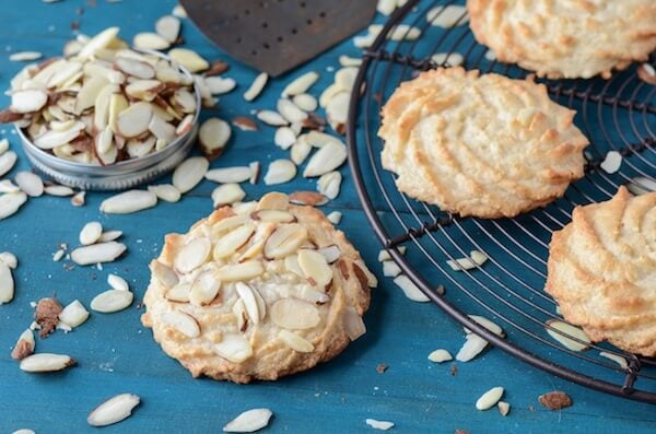 Ultimate Almond Cookies on a black rack with scattered almonds.