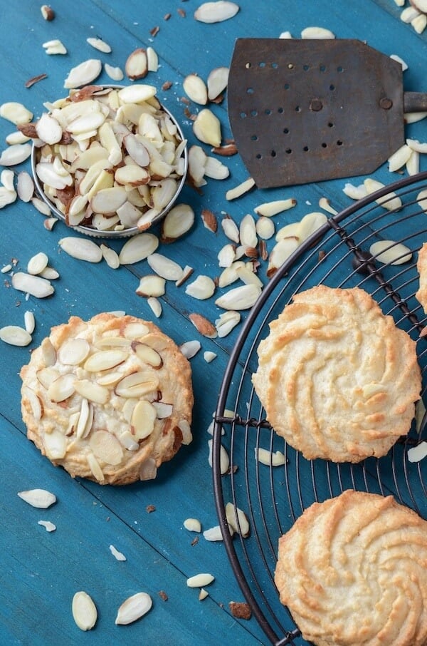 Ultimate Almond Cookies on a black rack with scattered almonds.