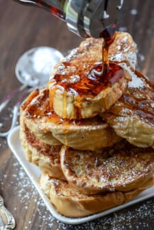 Maple Syrup Being Drizzled Over a Stack of Cuban Bread French Toast