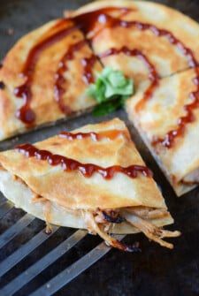 Sliced Pulled Pork and Caramelized Onion Quesadillas with barbecue sauce on top.