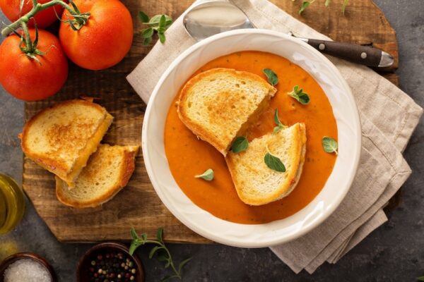 A bowl of homemade tomato soup with a grilled cheese sandwich.
