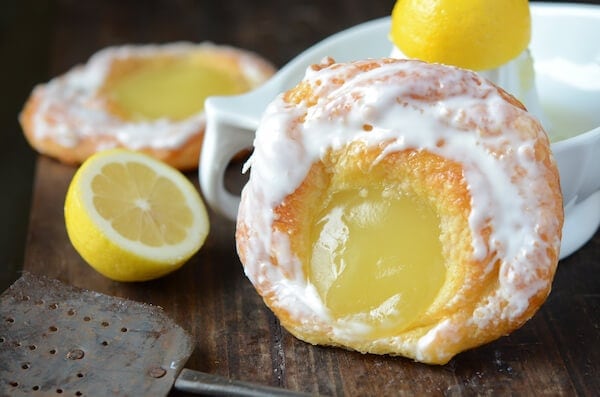 Two Lemon Danishes on a Table Beside a White Lemon Juicer