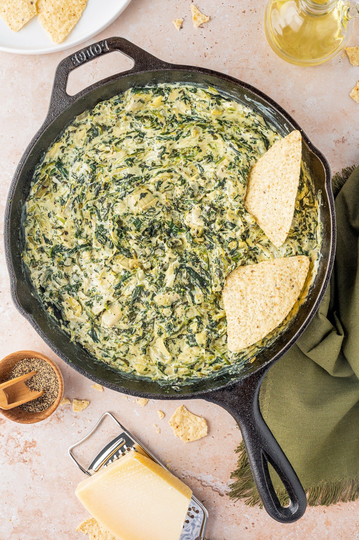 Hot spinach dip in a skillet with tortilla chips.