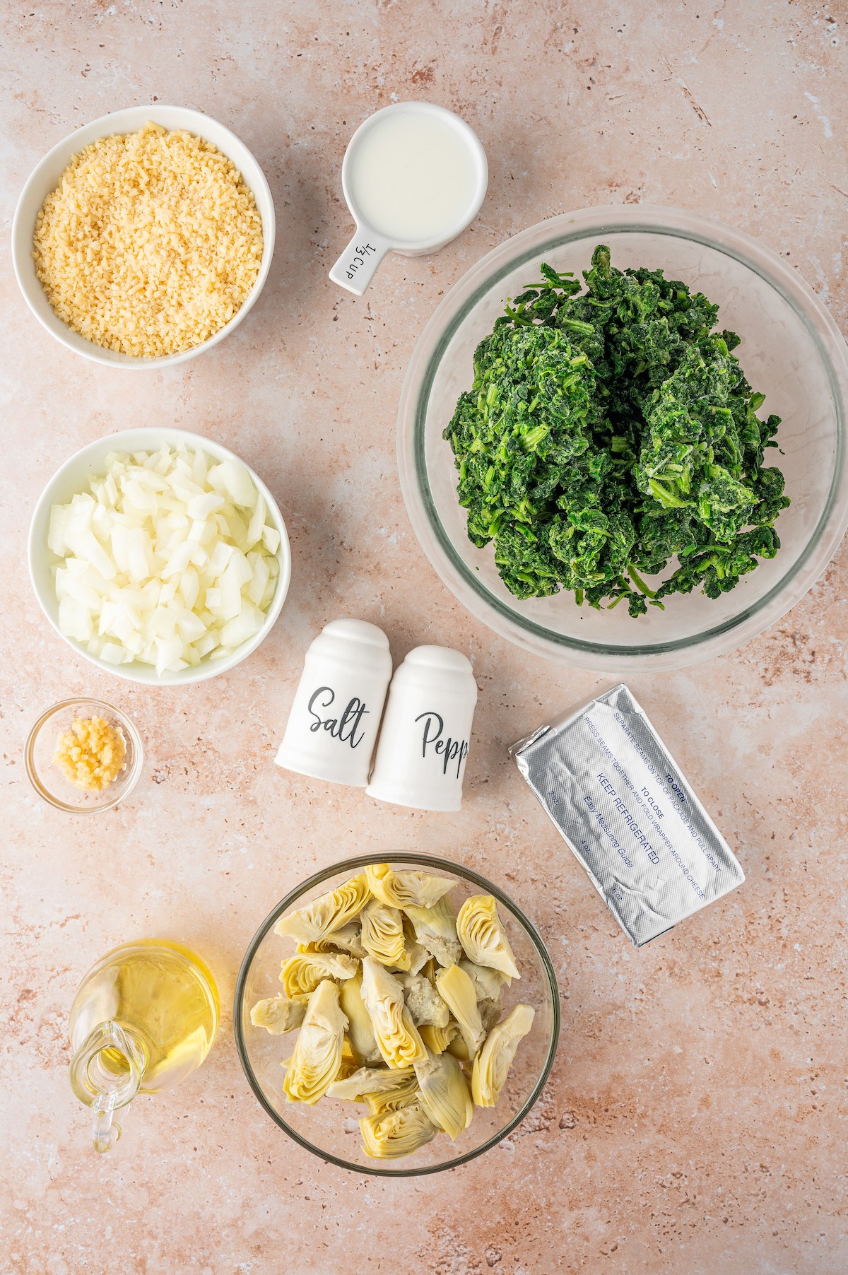 Ingredients for spinach artichoke dip arranged on a table.