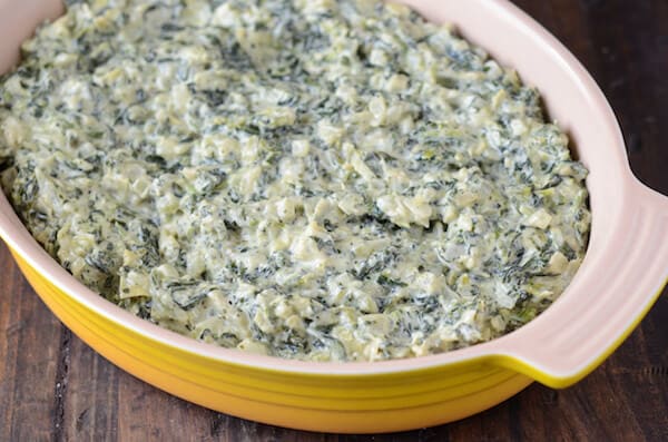 Stovetop Spinach and Artichoke Dip in a yellow dish.