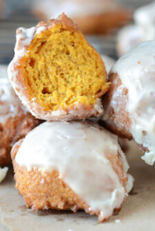 A group of Pumpkin Fritters with Cinnamon Glaze - one has a bite taken out of it.