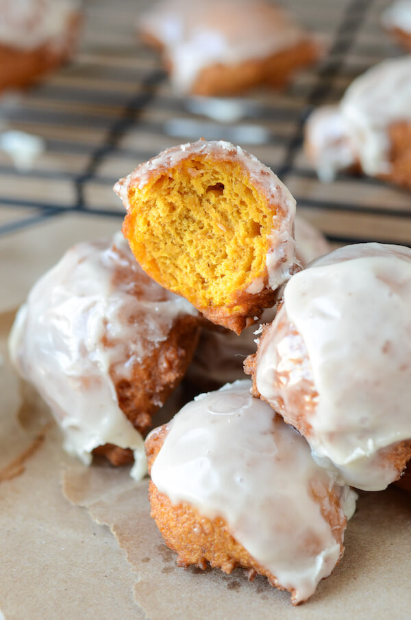Pumpkin Fritters topped with a cinnamon glaze piled on brown paper