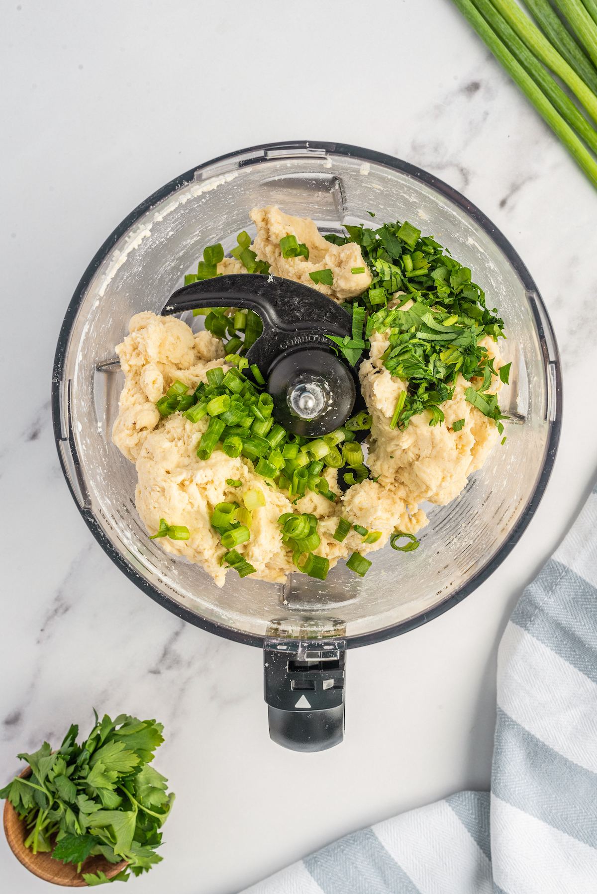 Biscuit dough with parsley and green onions in a food processor.