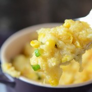 Spoonful of Southern Corn Pudding in a purple baking dish