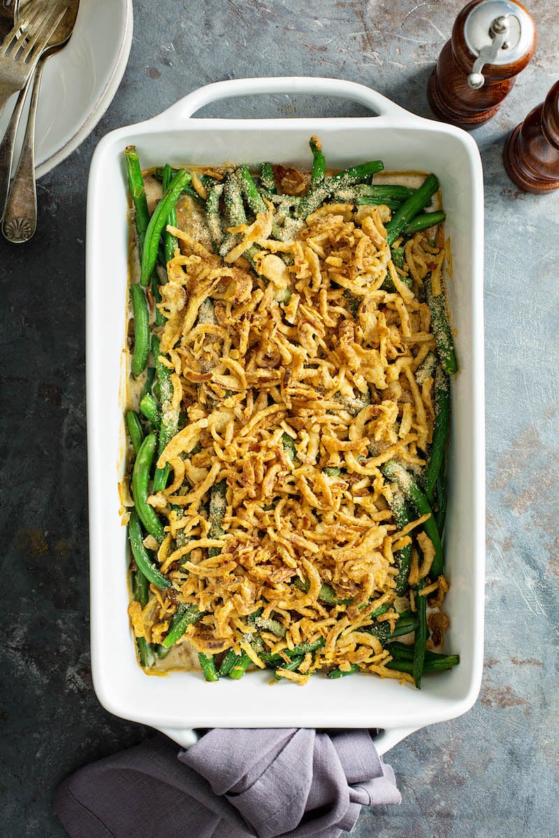 Green bean casserole topped with crispy onions in a white 9x13 casserole dish